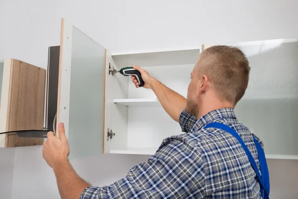 depositphotos stock photo carpenter drilling in cabinet